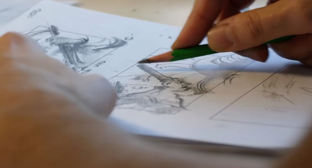 Close-up of an animator's hand sketching a storyboard concept on paper.
